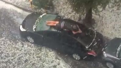 Video: Man protects his car from heavy hail by using his own body