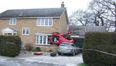 Horrific crash leaves car hanging from house