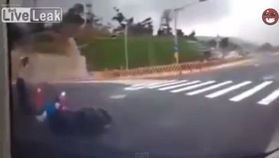 Video: Motorcyclist crashes off bike and then disappears down a hole in the road