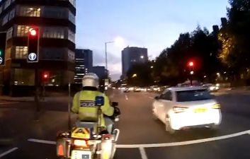 Video: London driver runs a red light; immediately caught out by police motorbike driving right alongside the car