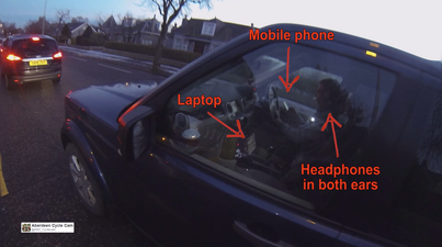 Video: Worst driver EVER caught using mobile phone & laptop while wearing headphones