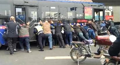 Video: Amazing footage of over 20 people rescuing a man trapped under a bus in China