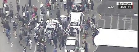 Video: Incredible scenes as rioters destroy a police car in Baltimore as violence erupts overnight