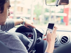 You can get away with using social media while driving… for now