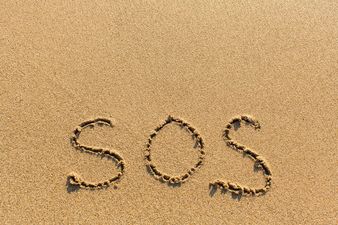 PICS: Couple rescued from deserted island after writing ‘SOS’ in the sand