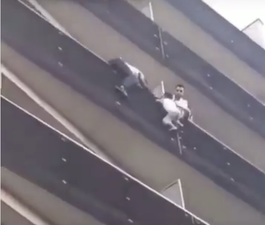 Heroic man climbs up apartment building to save child hanging from balcony