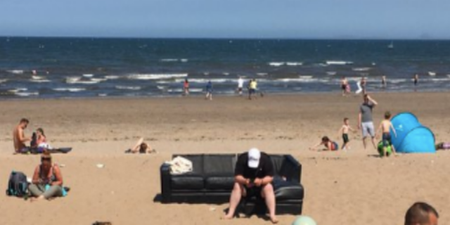 Man at the beach doesn’t fancy sunbathing, brings his own couch instead